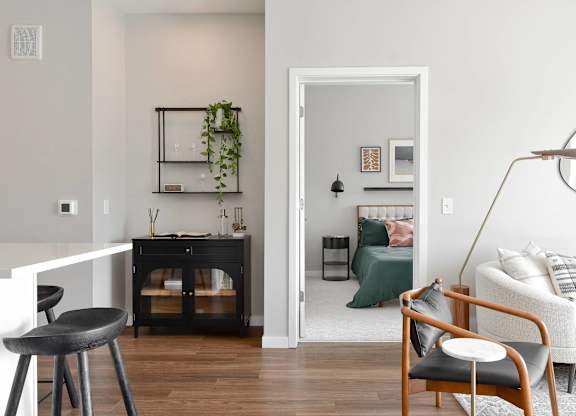 a living room with a couch and a chair and a bedroom with a bed at The Hallon Apartments, Minnesota, 55343
