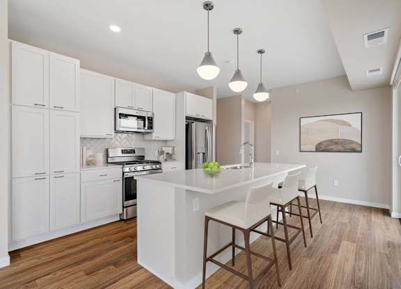 modern eat-in kitchen with island and stainless steel appliances at The Hallon Apartments, Hopkins