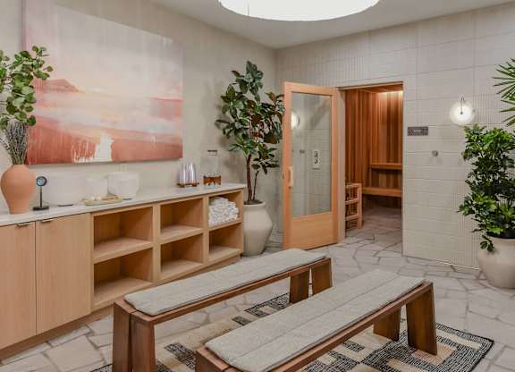 A room with a wooden bench and a painting on the wall.