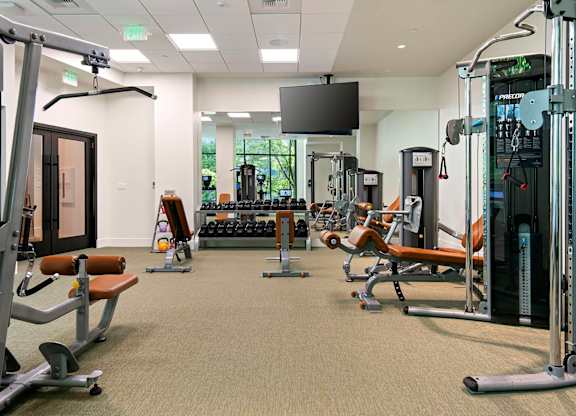 A gym with a variety of equipment including weights and machines.