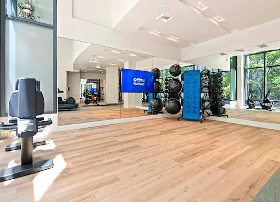 A gym with a variety of equipment including weights and exercise balls.