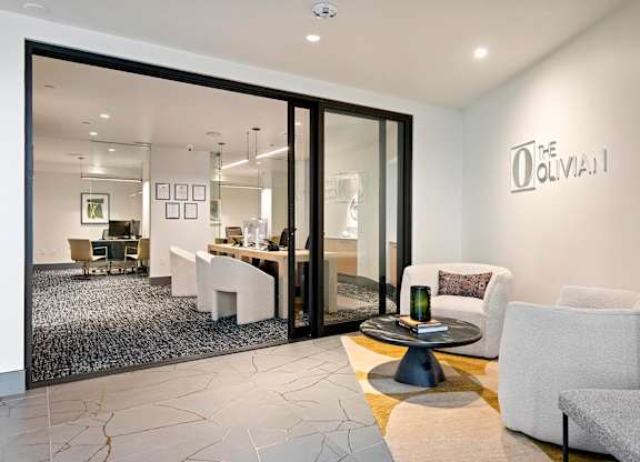A modern living room with a glass door leading to a dining area.