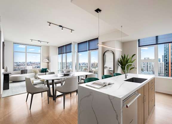 A modern kitchen with a marble island and a dining table with chairs.
