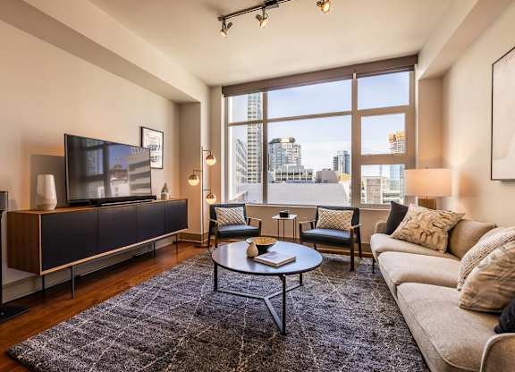 A living room with a large window overlooking the city.