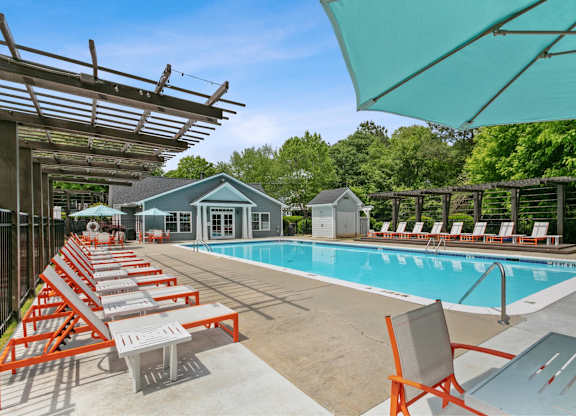 Pool with sun loungers at Aqua Sandy Springs apartments for rent in Sandy Springs, GA.