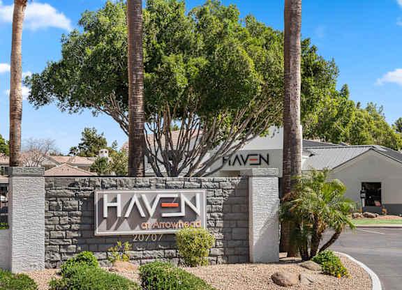 A sign for Haven at Arrowhead with a tree in front.