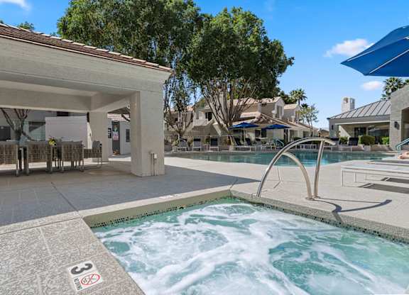 A hot tub in the middle of a pool surrounded by a building.