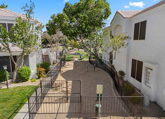 A gated community with white houses and a playground.