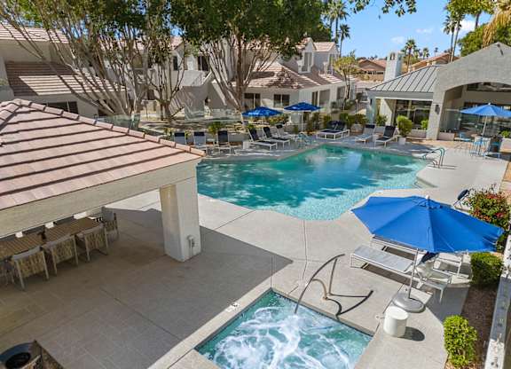A pool with a slide and a hot tub.