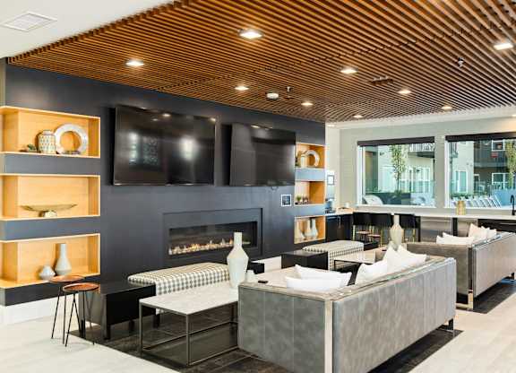 A modern living room with a fireplace and a large grey sofa.
