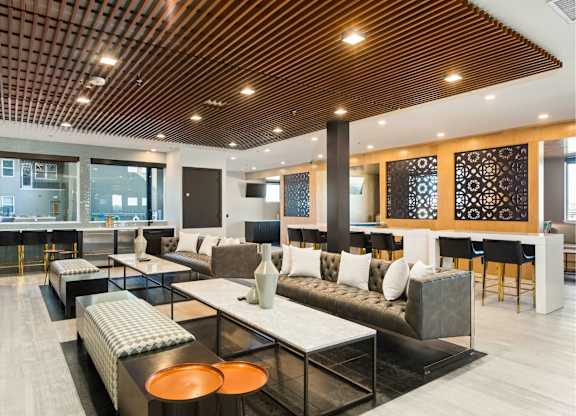 A modern living room with a wooden ceiling and a black and white sofa.