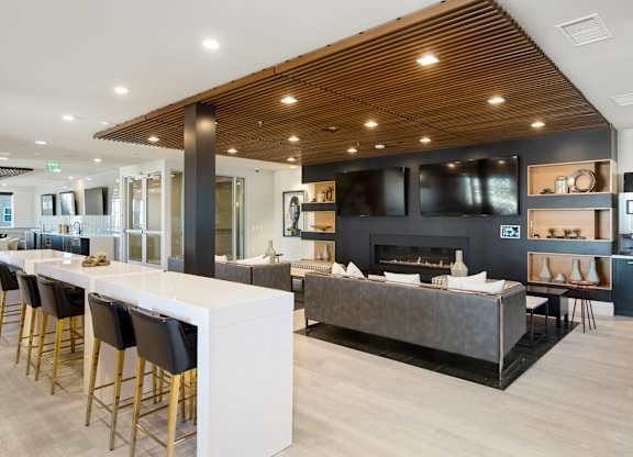 A modern kitchen with a bar area and a fireplace in the living room.