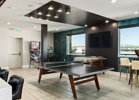 A room with a ping pong table and a television.
