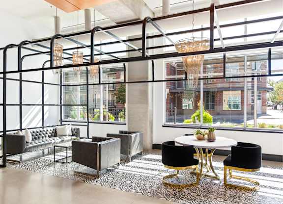 A modern living room with a glass wall and a black and white rug.
