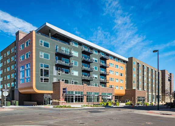 A large, modern multi-story building with a mix of residential and commercial spaces.