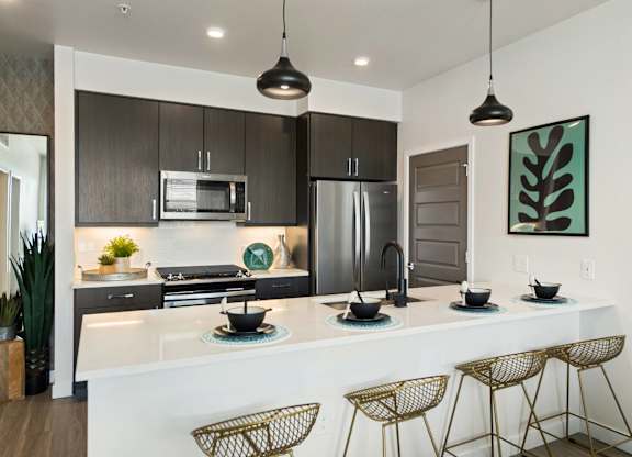 A modern kitchen with a white countertop and dark brown cabinets.