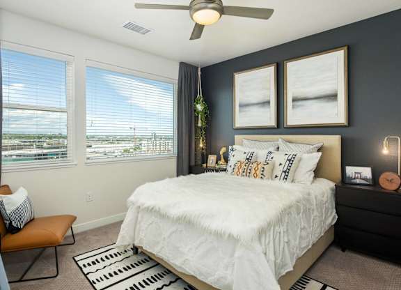 A bedroom with a large bed and a ceiling fan.