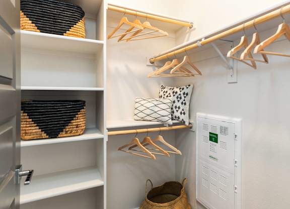 A white closet with a white shelf and a white wall.
