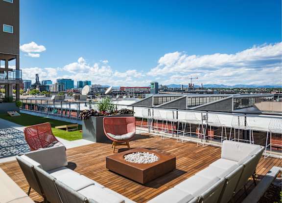 A patio with a table and chairs overlooking a cityscape.
