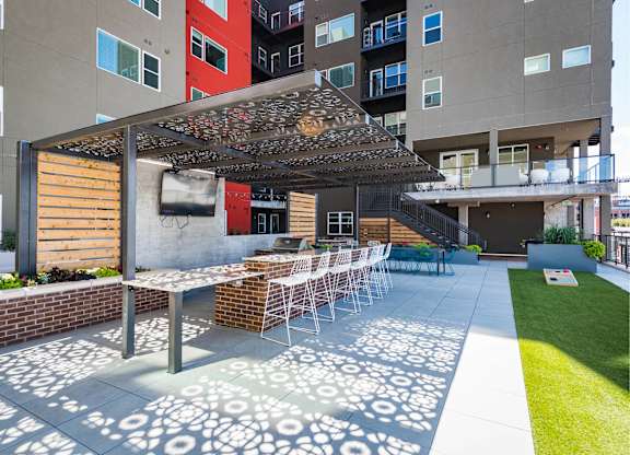 A patio with a table and chairs under a pergola.