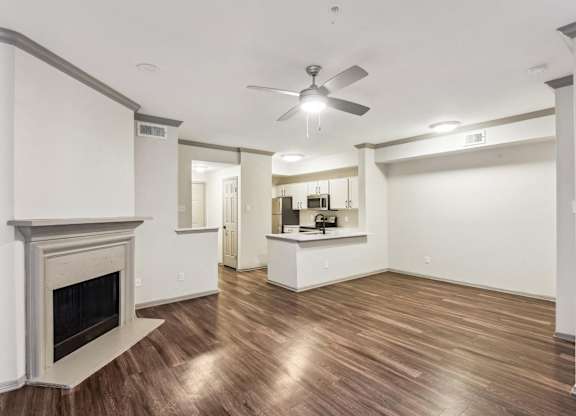 A room with a fireplace and a ceiling fan.