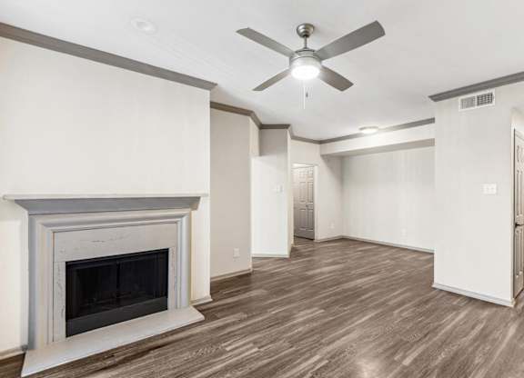 A room with a fireplace and a ceiling fan.