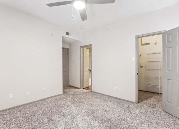 A room with a ceiling fan and two doors.
