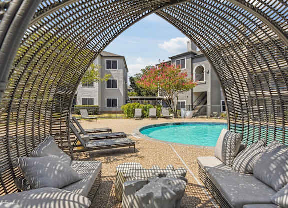 A large outdoor seating area with a pool and a building in the background.