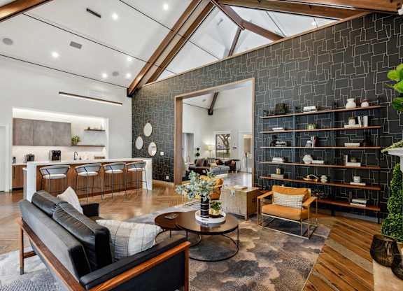 A modern living room with a black couch and a wooden coffee table.