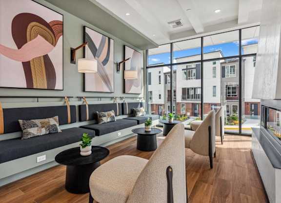 A modern living room with a long couch and a large abstract painting above it.