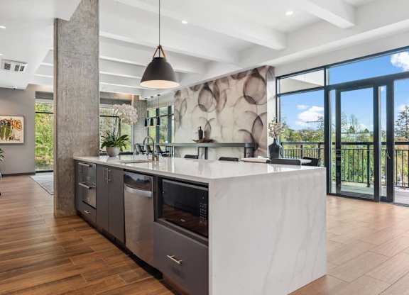 A modern kitchen with a large island and a view of the outdoors.