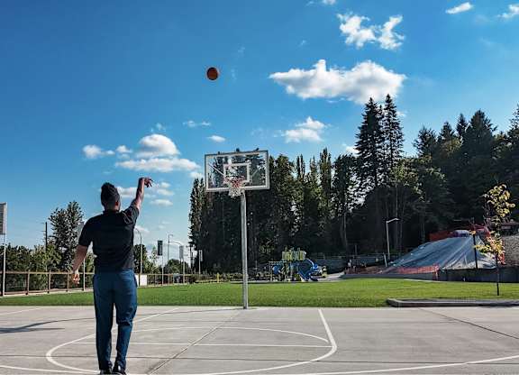 A man is playing basketball on an outdoor court.