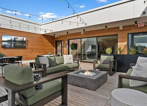 A patio with a fire pit and seating area.