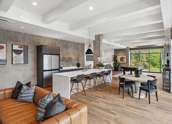 A modern living room with a brown leather sofa and a dining table with chairs.