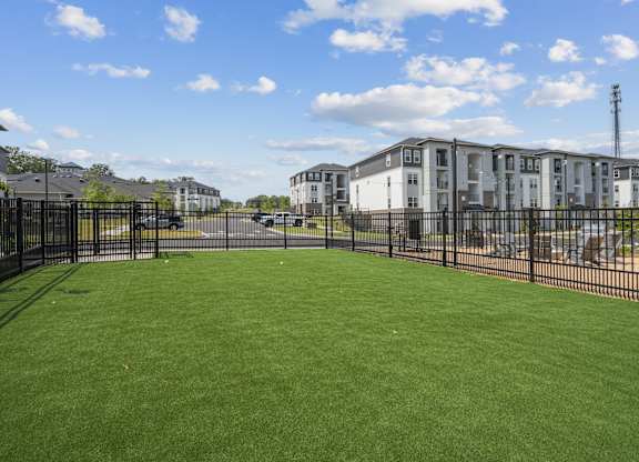 A large grassy area in front of apartment buildings.