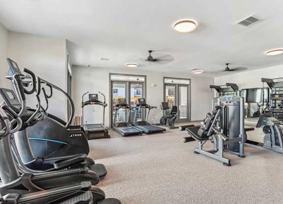 A spacious gym with treadmills, elliptical machines, and other exercise equipment.