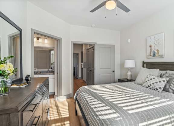 A bedroom with a large bed and a ceiling fan.