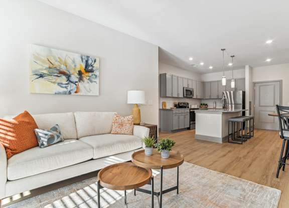 Open concept living room that leads into the kitchen with hardwood floors in our apartments for rent in Indian Land, SC.