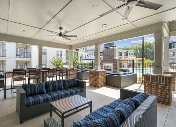 A patio with a black sofa and a table.