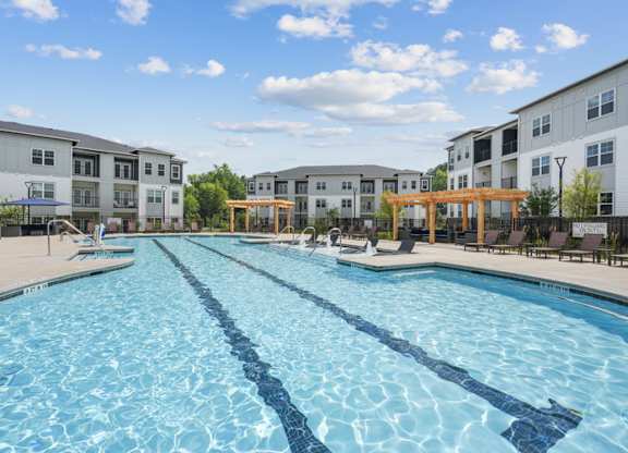 A large swimming pool in front of apartment buildings.