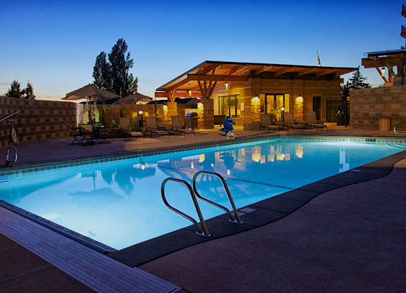 a swimming pool in front of a hotel at dusk