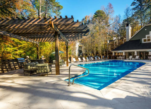 a swimming pool with chairs and umbrellas around it