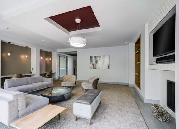 A modern living room with a grey sofa set and a fireplace.