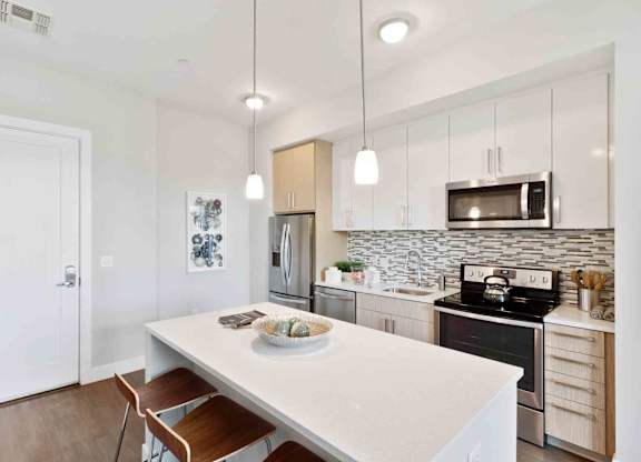 A kitchen with a white table and a white fridge.