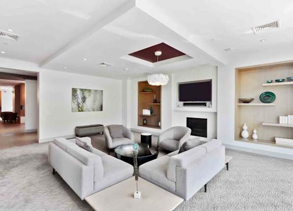 A living room with a grey couch and a fireplace.