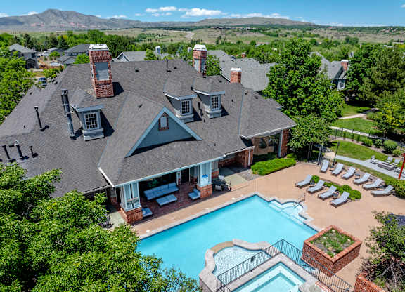 A large house with a pool and a mountain in the background.