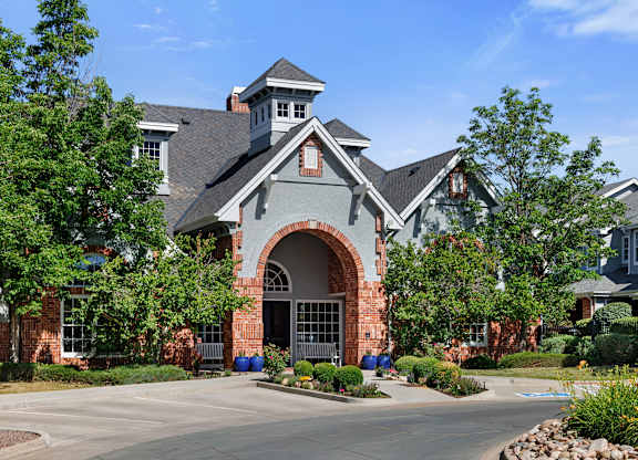A large house with a grey roof and a red brick archway entrance.