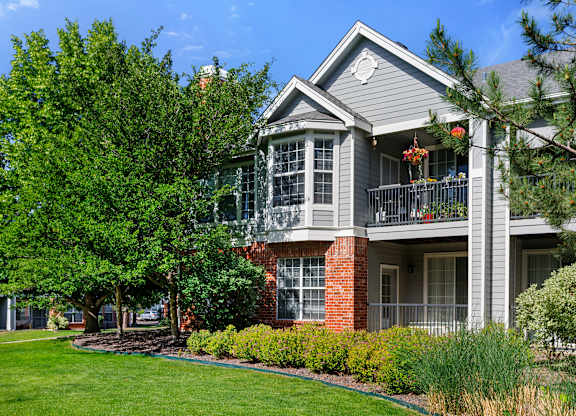 A house with a grey roof and a balcony with flowers on it.