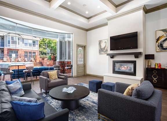 A living room with a fireplace and a television mounted above it.