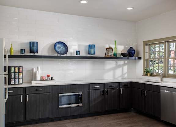 A kitchen with dark wood cabinets and a white backsplash.